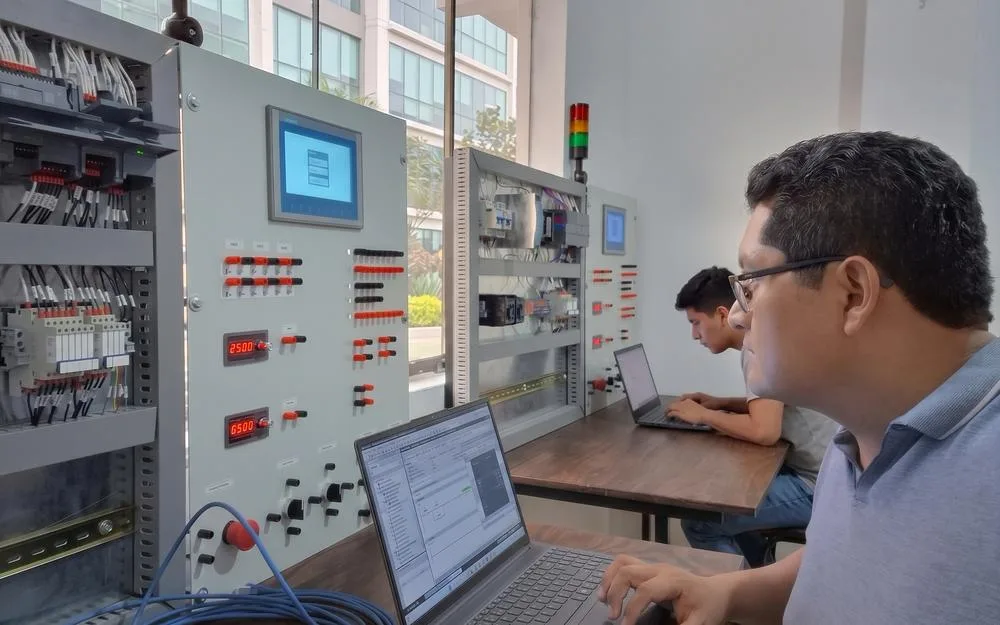 Módulo de entrenamiento con tablero industrial Siemens S7-1200, HMI KTP700 y laptop con TIA Portal V20 en el laboratorio de ProyTech Academy